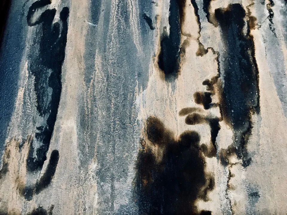 Dark mould and damp staining spreading across a wall